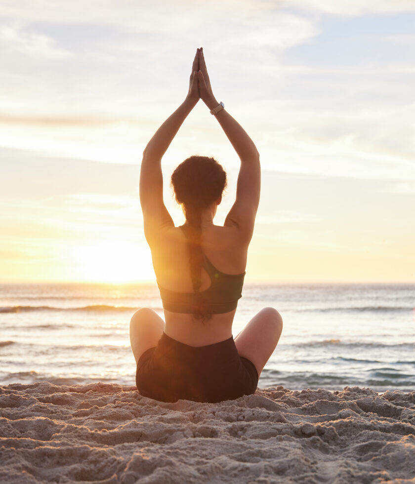 Woman, yoga and meditation on the beach sunset for zen workout or spiritual wellness outdoors. Fema.